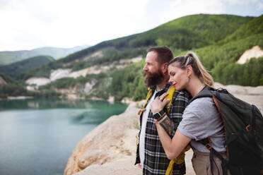 Ein glückliches reifes Paar auf Wandertour im Sommerurlaub, das sich am See ausruht. - HPIF07458