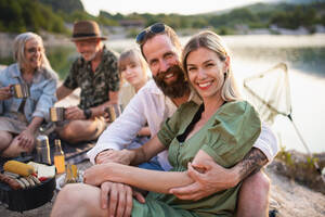 Eine glückliche Mehrgenerationenfamilie auf Sommerurlaubsreise, Grillparty am See. - HPIF07489