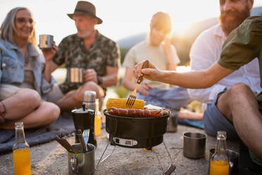 Eine glückliche Mehrgenerationenfamilie auf Sommerurlaubsreise, Grillparty am See. - HPIF07492