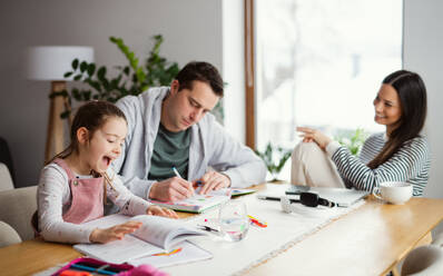 Eltern mit Schulmädchen drinnen zu Hause, Fernstudium und Home-Office-Konzept. - HPIF07540