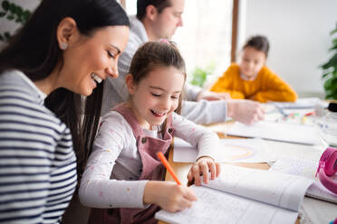 Parents with school girls daughters indoors at home, distance learning. - HPIF07542