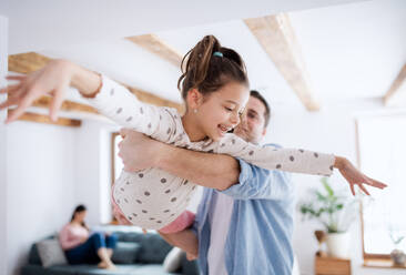 Porträt eines fröhlichen kleinen Mädchens mit Vater, das sich zu Hause amüsiert. - HPIF07559