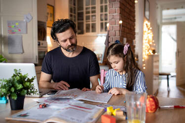 Älterer Vater mit kleiner Tochter in der Küche, Fernstudium, Home Office und Schulkonzept. - HPIF07693