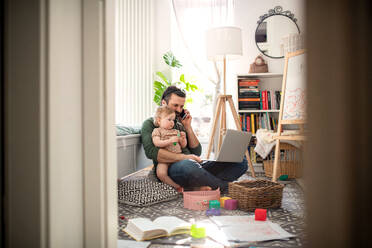 Fleißiger Vater arbeitet mit kleinem Kleinkind Tochter im Schlafzimmer Home-Office-Konzept. - HPIF07712