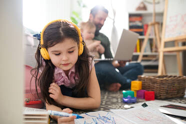 Busy father working with small daughters in bedroom, home office and distance learning concept. - HPIF07715