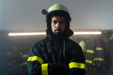 A young African-American firefighter in fire station at night. - HPIF07729