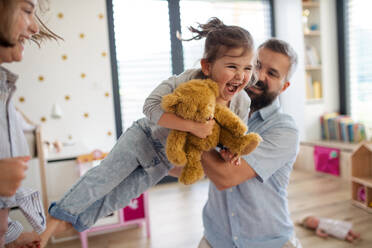 A father with daughters indoors at home, playing, laughing and having fun. - HPIF07816