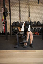 Älterer Mann mit Beinprothese trainiert im Fitnessstudio - JJF00355