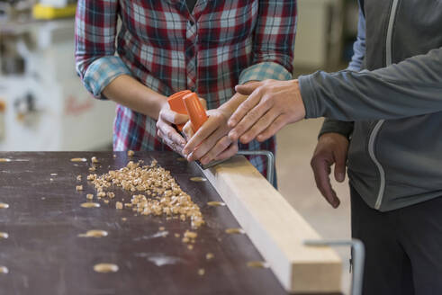 Craftsman assisting trainee in workshop - PAF01972