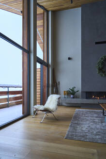 Chair kept by window in ski chalet - JAHF00176