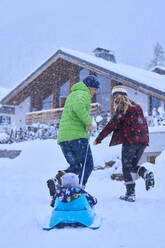 Glückliche Mutter und Vater mit Sohn genießen im Schnee - JAHF00187