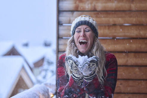 Cheerful mature woman enjoying snow - JAHF00196