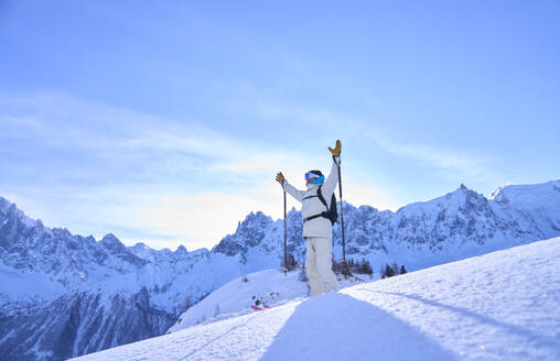 Älterer Mann mit Skistöcken im Schnee stehend - JAHF00201