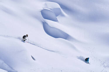 Älterer Mann und Frau beim Skifahren im Schnee an einem sonnigen Tag - JAHF00213