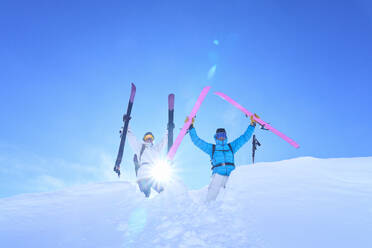 Unbeschwerter Mann und Frau mit Himmel, die sich im Schnee vergnügen - JAHF00224