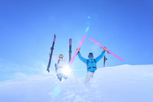 Carefree man and woman with skies enjoying in snow - JAHF00224