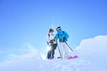 Reifes Paar stehend mit Skiern im Schnee - JAHF00226