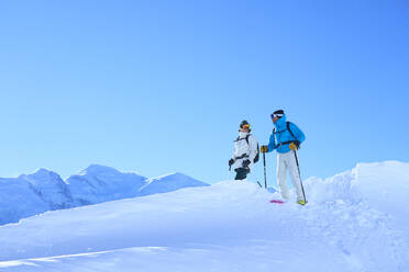 Man and woman with skies standing under sky - JAHF00230