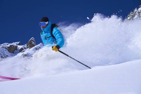 Man wearing ski goggles skiing in snow - JAHF00246