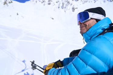 Lächelnder reifer Mann mit Skibrille auf einem Berg - JAHF00254