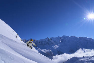 Frau beim Skifahren im Schnee an einem sonnigen Tag - JAHF00259