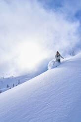 Frau beim Skifahren auf einem schneebedeckten Berg - JAHF00266