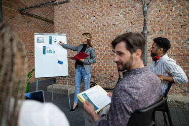 Junge Geschäftsleute, die im Büro stehen und arbeiten, Zusammenarbeit, Präsentation und ein Brainstorming-Konzept. - HPIF08025