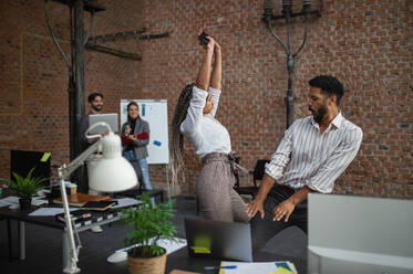 Fröhliche junge Geschäftsleute haben Spaß im Büro, ein Konzept für Zusammenarbeit und Brainstorming. - HPIF08026