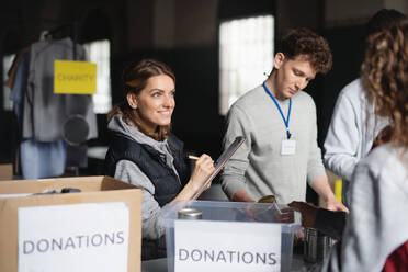 Eine Gruppe von Freiwilligen arbeitet im Spendenzentrum der Gemeinde und sortiert Kleidung und Lebensmittelkonserven. - HPIF08078