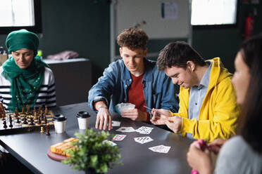 Eine Gruppe glücklicher Menschen spielt Karten und Brettspiele in einem Gemeinschaftszentrum, in dem auch Menschen mit Behinderungen willkommen sind. - HPIF08106