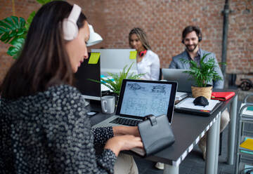 Young and old architects sitting and working at desk in a office, cooperation and coworking concept. - HPIF08153