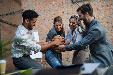 A group of cheerful young businesspeople playing basketball in office, taking a break concept. - HPIF08168