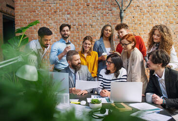 Eine Gruppe von Unternehmern und Architekten, die in einem Büro an einem Projekt arbeiten und Fragen diskutieren. - HPIF08202