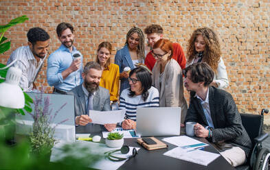 Eine Gruppe von Unternehmern und Architekten, die in einem Büro an einem Projekt arbeiten und Fragen diskutieren. - HPIF08203