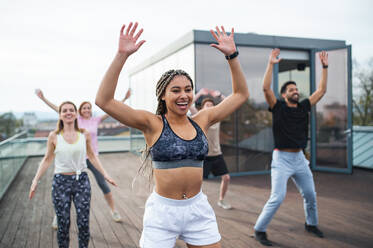 Eine Gruppe junger Menschen, die auf einer Terrasse Sport treiben, ein Konzept für Sport und gesunde Lebensweise. - HPIF08217