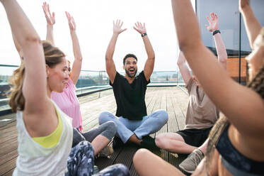 Eine Gruppe junger Menschen, die auf einer Terrasse Sport treiben, ein Konzept für Sport und gesunde Lebensweise. - HPIF08230