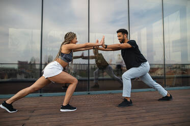 Ein junges Paar macht Planke Übung Workout im Freien auf der Terrasse, Sport und gesunden Lebensstil Konzept. - HPIF08237