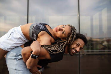 Ein junges Paar, das sich nach dem Sport auf der Terrasse amüsiert, ein Konzept für Sport und gesunden Lebensstil. - HPIF08239