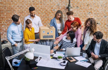 Eine Gruppe von Unternehmern und Architekten, die sich in einem Büro amüsieren und an einem Projekt arbeiten. - HPIF08249