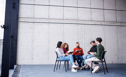 Männer und Frauen sitzen während der Gruppentherapie im Kreis, lesen und reden. - HPIF08272