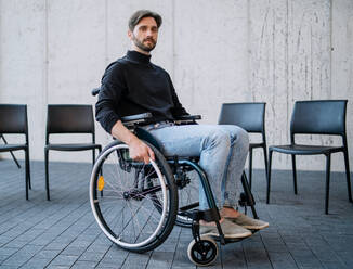 A portrait of sad man in wheelchair on group therapy, looking at camera. - HPIF08314