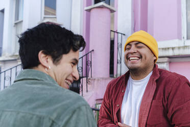 Cheerful man having fun with brother in front of building - ASGF03441