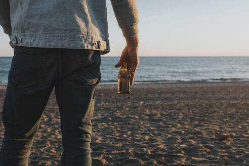 Hand eines Mannes mit Bier am Strand stehend - DMGF01063