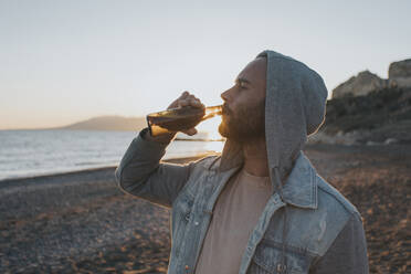 Man drinking beer at beach - DMGF01065