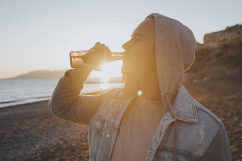 Mann trinkt Bier bei Sonnenuntergang - DMGF01066