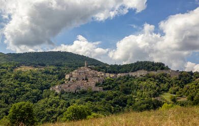 Italien, Toskana, Castelnuovo di Val di Cecina, Blick auf ein Dorf am Hang und die umliegende Landschaft im Sommer - MAMF02598