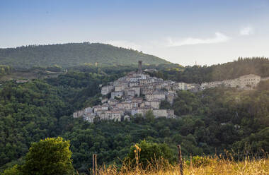 Italien, Toskana, Castelnuovo di Val di Cecina, Blick auf ein Dorf am Hang und die umliegende Landschaft im Sommer - MAMF02599