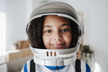 Smiling elementary girl wearing space suit at home - EBBF08253