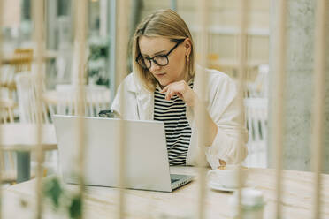 Geschäftsfrau arbeitet am Laptop am Tisch im Café - VSNF00583