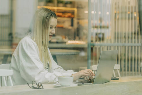 Freiberufler arbeitet am Laptop im Café - VSNF00608